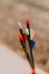 Close-up of colorful arrows outdoors, showcasing details of archery equipment.